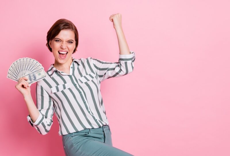 Portrait of cheerful delighted girl hold money fan