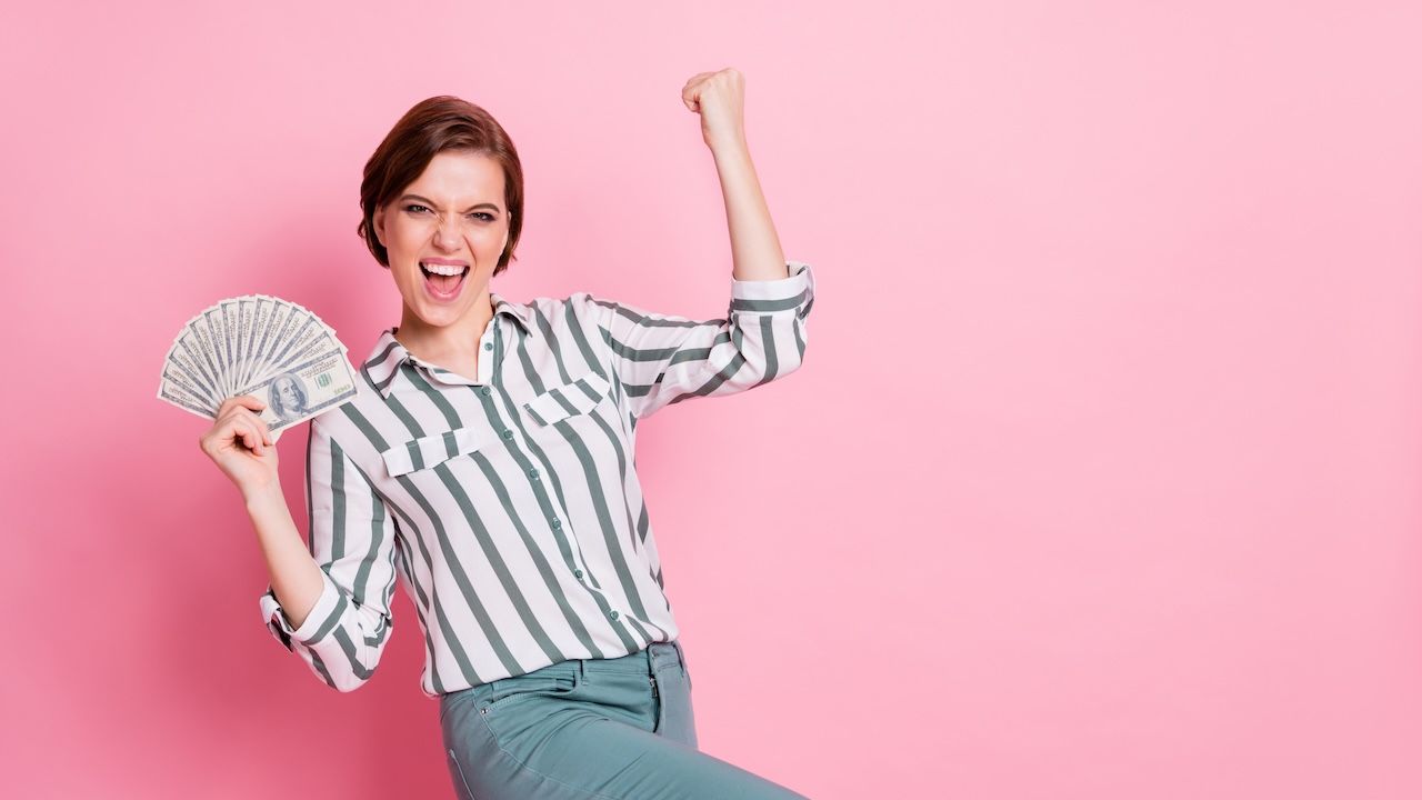 Portrait of cheerful delighted girl hold money fan