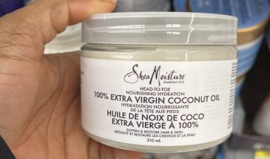 person holding a jar of SheaMoisture 100% Extra Virgin Coconut Oil
