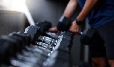 Man, hands or dumbbells in gym workout, training or exercise for strong muscle growth, healthcare wellness or bodybuilding. Zoom, texture or heavy metal weights for fitness coach or personal trainer