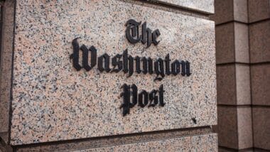 loseup of The Washington Post newspaper logo sign on the facade of a building downtown Washington DC