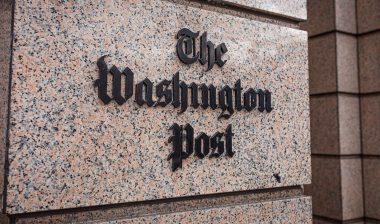 loseup of The Washington Post newspaper logo sign on the facade of a building downtown Washington DC