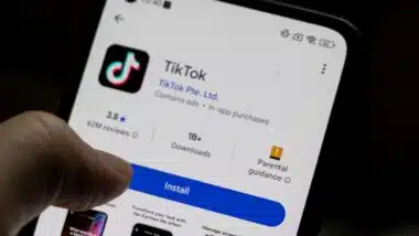 A smartphone displaying the TikTok app, featuring download statistics, ratings, and installation button.