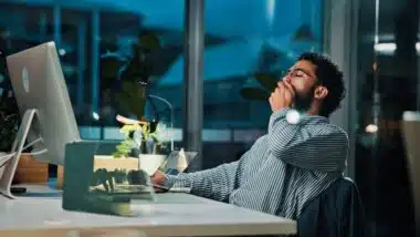 Tired, businessman and night with yawn on computer for project deadline or exhausted in office.
