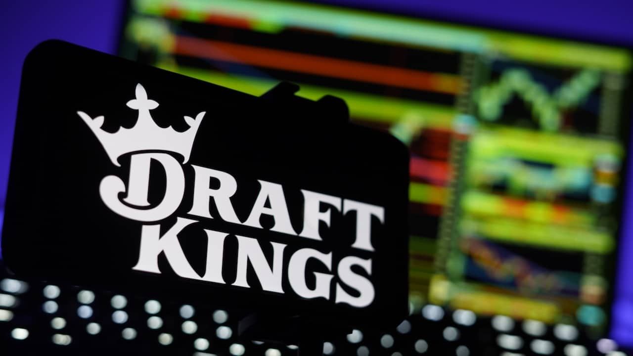 DraftKings Logo On Mobile And Computer Screens With Chart Background