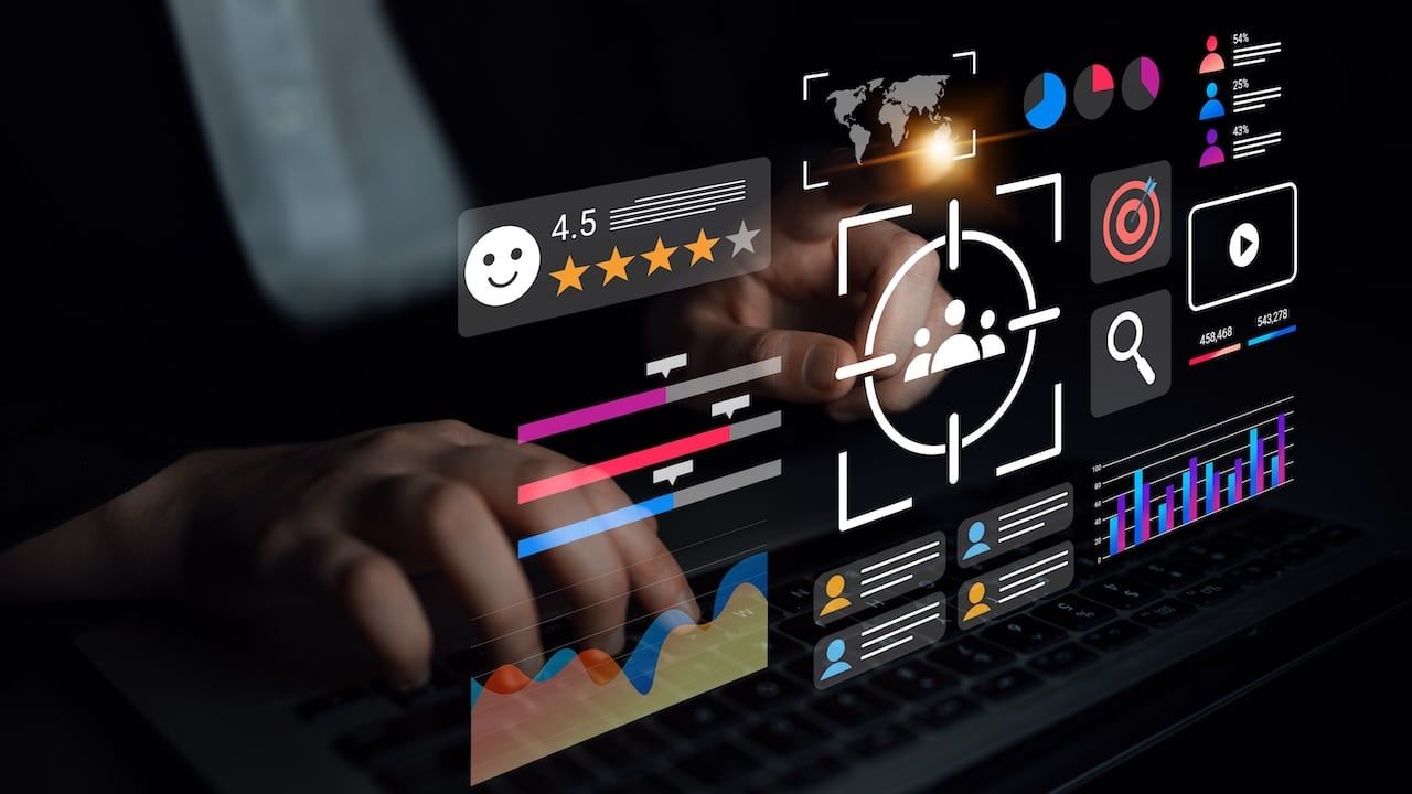 A person interacts with a laptop, surrounded by a dynamic digital interface showcasing various metrics