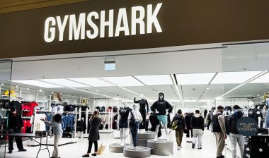 Inside the Gymshark shop, shoppers browse athleticwear around mannequins and bright lighting.