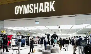 Inside the Gymshark shop, shoppers browse athleticwear around mannequins and bright lighting.