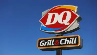 Close up of a Dairy Queen store sign in a deep blue sky