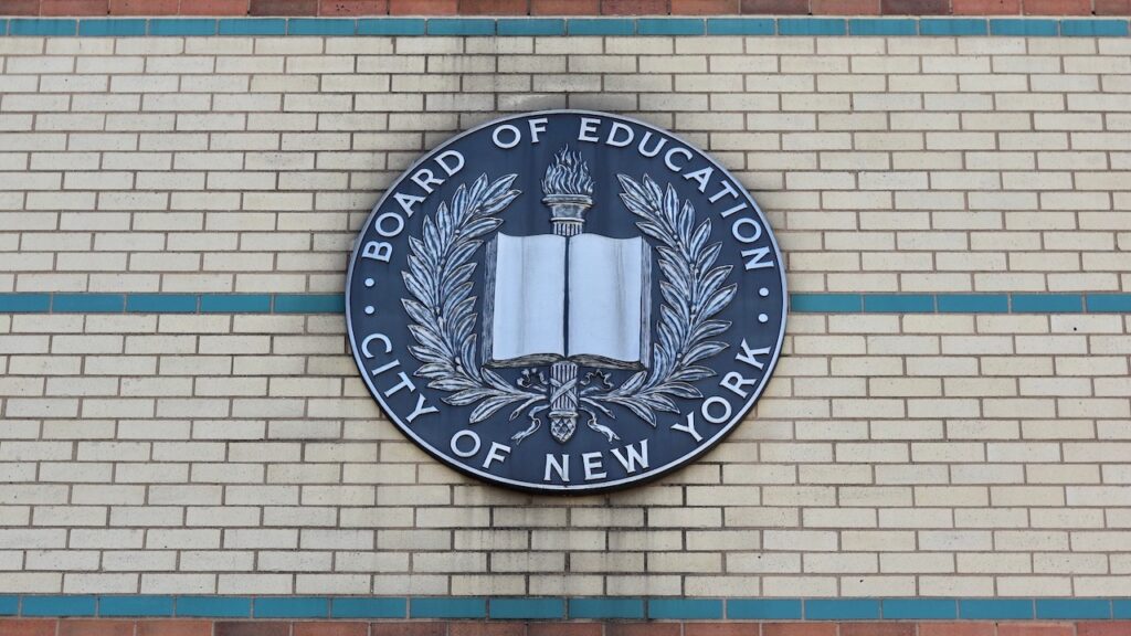 Board of Education City of New York Emblem Hangs on the Side of a Brown, Beige, and Green Brick Manhattan School Building in Uptown Washington Heights