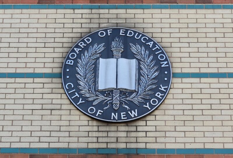 Board of Education City of New York Emblem Hangs on the Side of a Brown, Beige, and Green Brick Manhattan School Building in Uptown Washington Heights