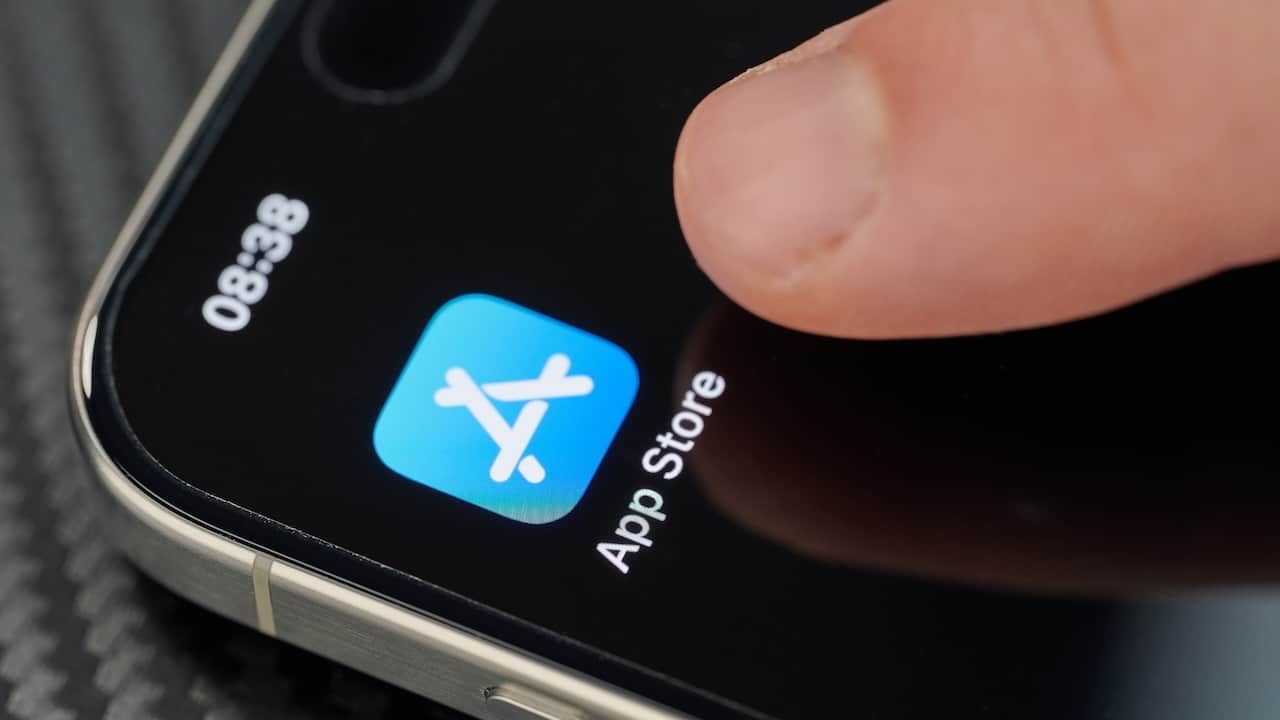 Touching top open App Store app icon with finger on iphone 15 pro max close up view
