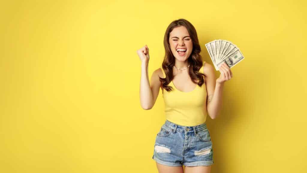 Enthusiastic smiling woman showing money cash,