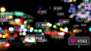 Image of social media icons and numbers over out of focus city lights.