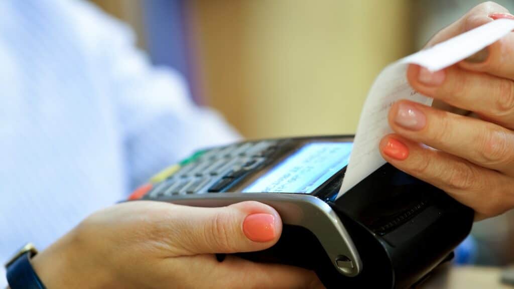 processing a payment using a card reader and is receiving a printed receipt for their transaction