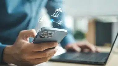 Business professional using smartphone for mobile banking with digital bank interface, representing online payment, secure transaction and financial technology innovation concept.