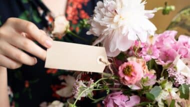 Woman looking at tag on flowers