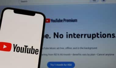 YouTube logo on a smartphone screen with the YouTube Premium interface in the background.