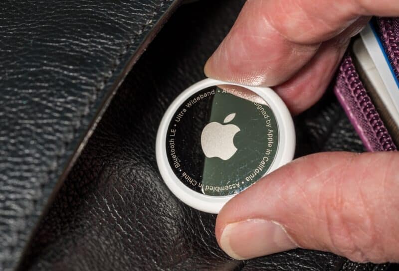 Apple AirTag device inserted into a leather purse as concept for stalking or secret tracking of a person