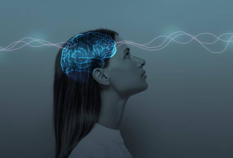 Young girl with closed eyes and neon glowing brain.