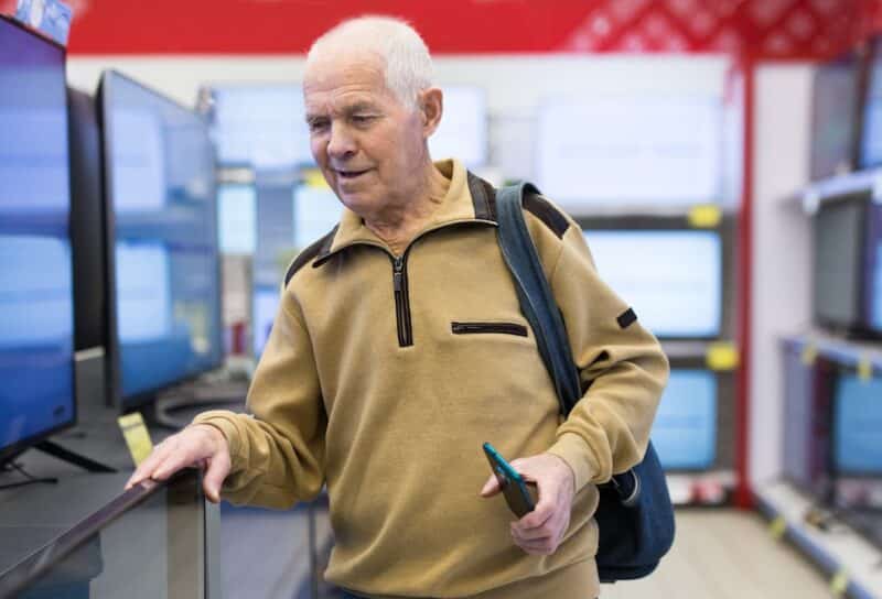senor man pensioner buying modern digital televisor