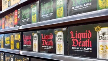 A view of several shelves dedicated to cases of Liquid Death water, on display at a local grocery store.