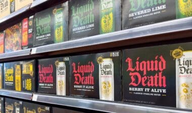 A view of several shelves dedicated to cases of Liquid Death water, on display at a local grocery store.