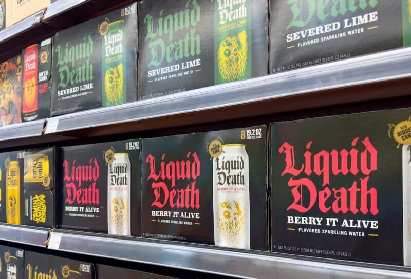 A view of several shelves dedicated to cases of Liquid Death water, on display at a local grocery store.
