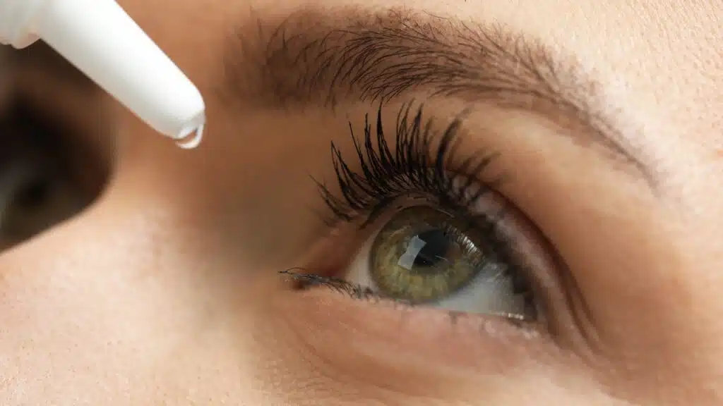 Woman applying medical eye drops