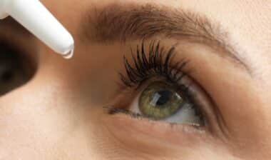 Woman applying medical eye drops