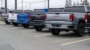 A row of luxury new General Motors Corporation Sierra 1500 trucks for sale at an automotive dealership lot.