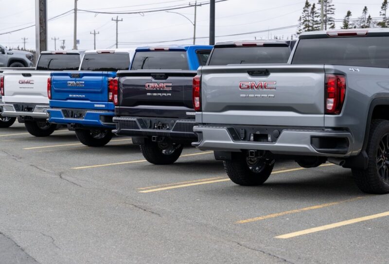 A row of luxury new General Motors Corporation Sierra 1500 trucks for sale at an automotive dealership lot.