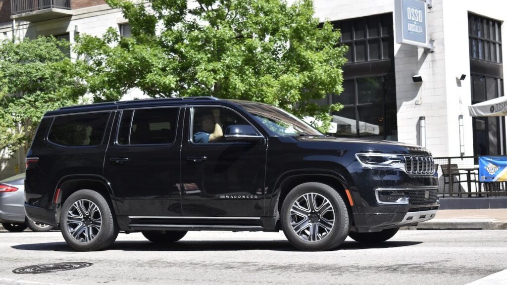 A black Jeep Grand Wagoneer cruising through the downtown district of Houston.