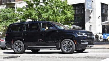 A black Jeep Grand Wagoneer cruising through the downtown district of Houston.