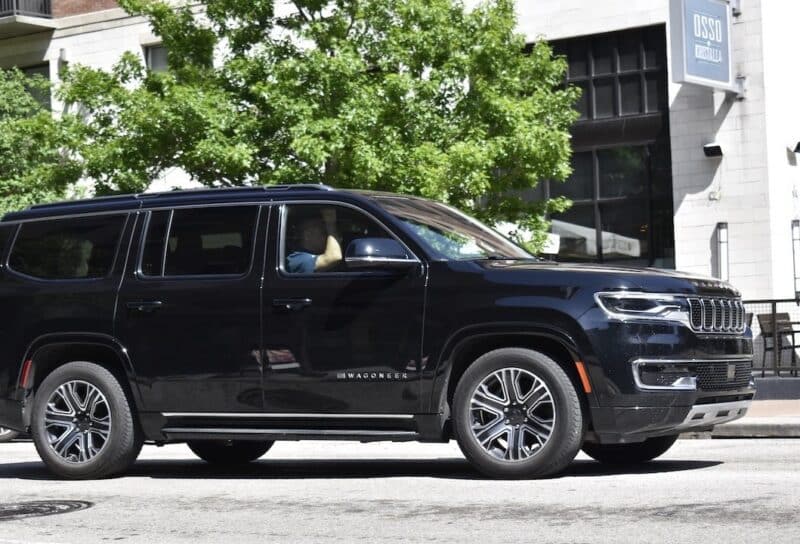 A black Jeep Grand Wagoneer cruising through the downtown district of Houston.