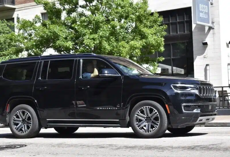 A black Jeep Grand Wagoneer cruising through the downtown district of Houston.
