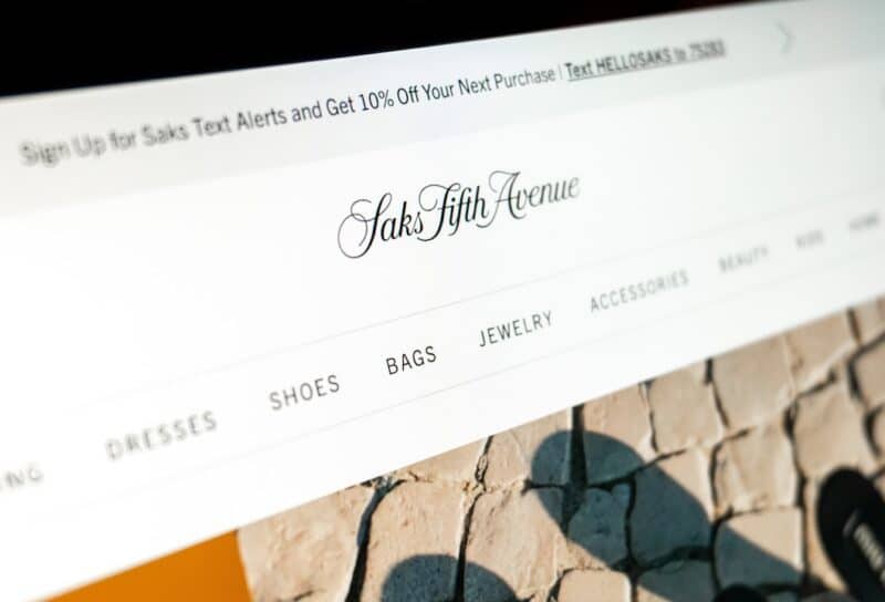 saks fifth avenue online store displaying luxury fashion items and categories on a monitor
