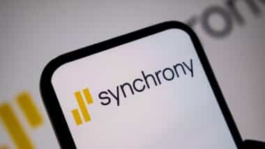 Close up view of mobile device screen presenting the yellow and black Synchrony brand logo