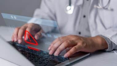 Healthcare cybersecurity warning on laptop represents medical data security