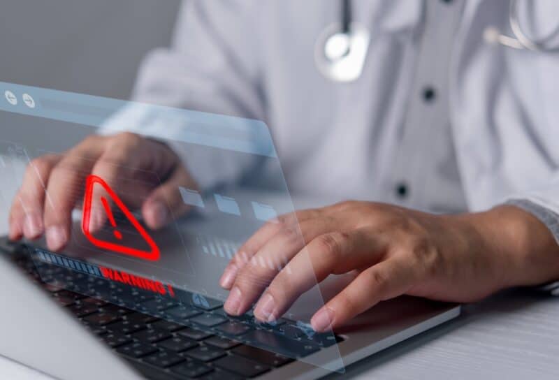 Healthcare cybersecurity warning on laptop represents medical data security