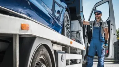Repo Company Driver Staying Next to His Towing Truck and Repossessed Vehicle by Bank.