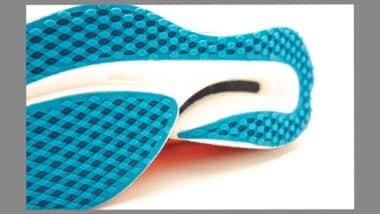 Close-up carbon plate and rigidness outsole of modern running racing shoes isolated on white background, waffle sole with carbon reinforced wave plate bottom geometry soft cushion energy return.