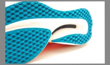Close-up carbon plate and rigidness outsole of modern running racing shoes isolated on white background, waffle sole with carbon reinforced wave plate bottom geometry soft cushion energy return.