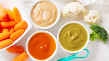 Baby food. Various kinds of bowls of fruit and vegetable puree with fresh vegetables, top view