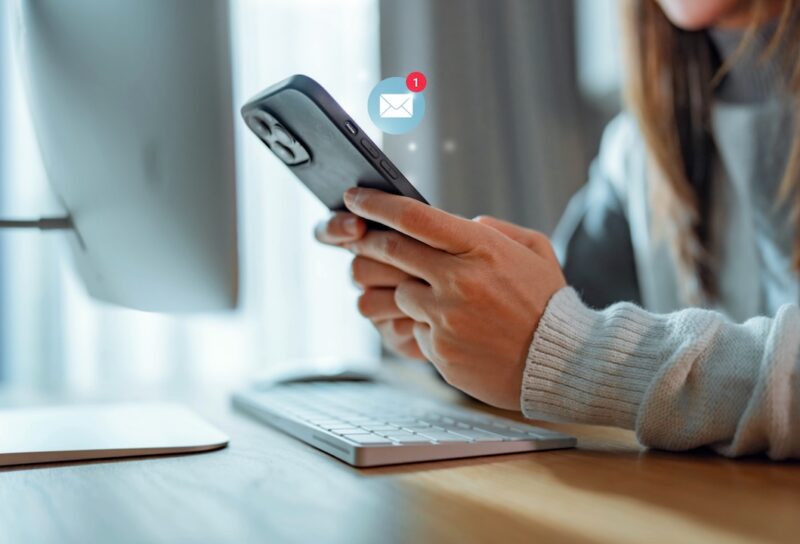 Woman hands using smartphone with 1 new email alert sign icon pop up