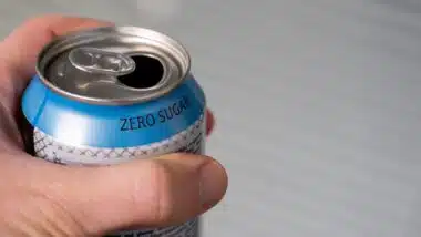 hand holding a zero sugar soda can.