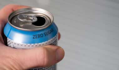hand holding a zero sugar soda can.