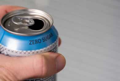 hand holding a zero sugar soda can.