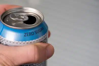 hand holding a zero sugar soda can.