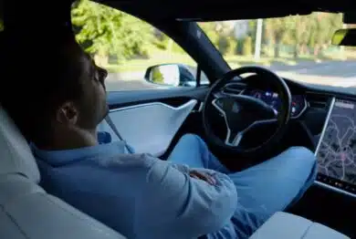 Male businessperson experience to ride an autonomous self driving electric car at urban road.